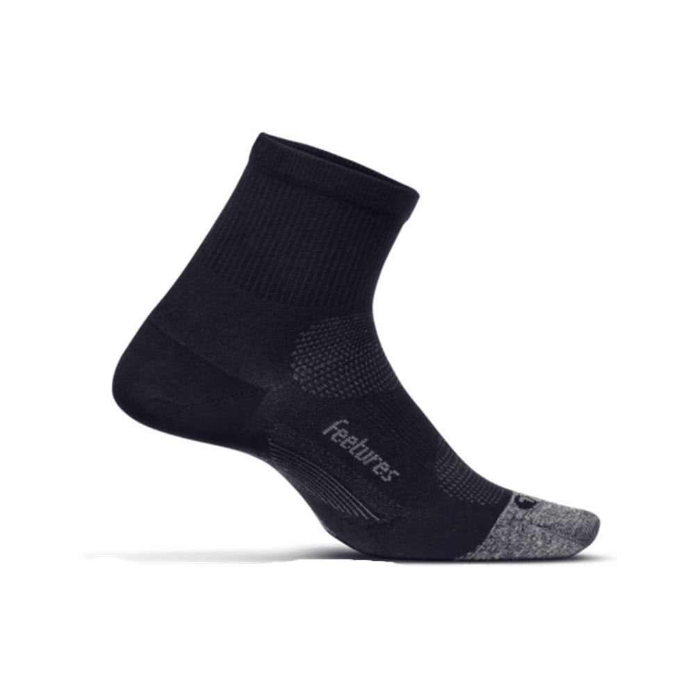 The FEETURES ELITE ULTRA LIGHT QUARTER SOCKS BLACK by Feetures features a single black and gray ankle sock with "feetures" written on the side. The sock includes ribbed, cushioned, and ventilated sections designed for comfort and performance with Ultra Light cushioning. Targeted Compression ensures a snug fit, while the anatomical design enhances overall support.