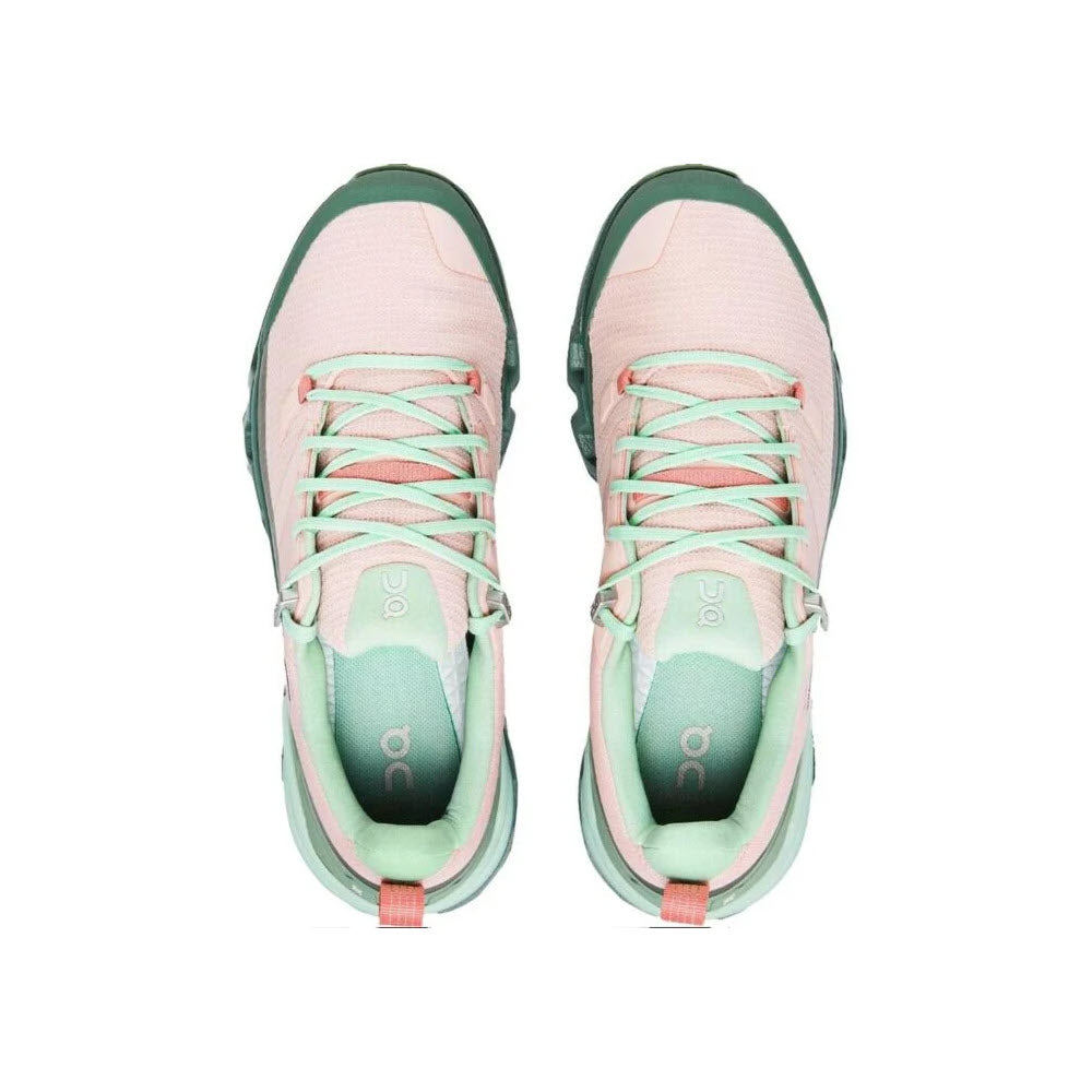 A pair of pink and green lightweight On Running sneakers viewed from above, showing the top and inside detailing of the shoes.