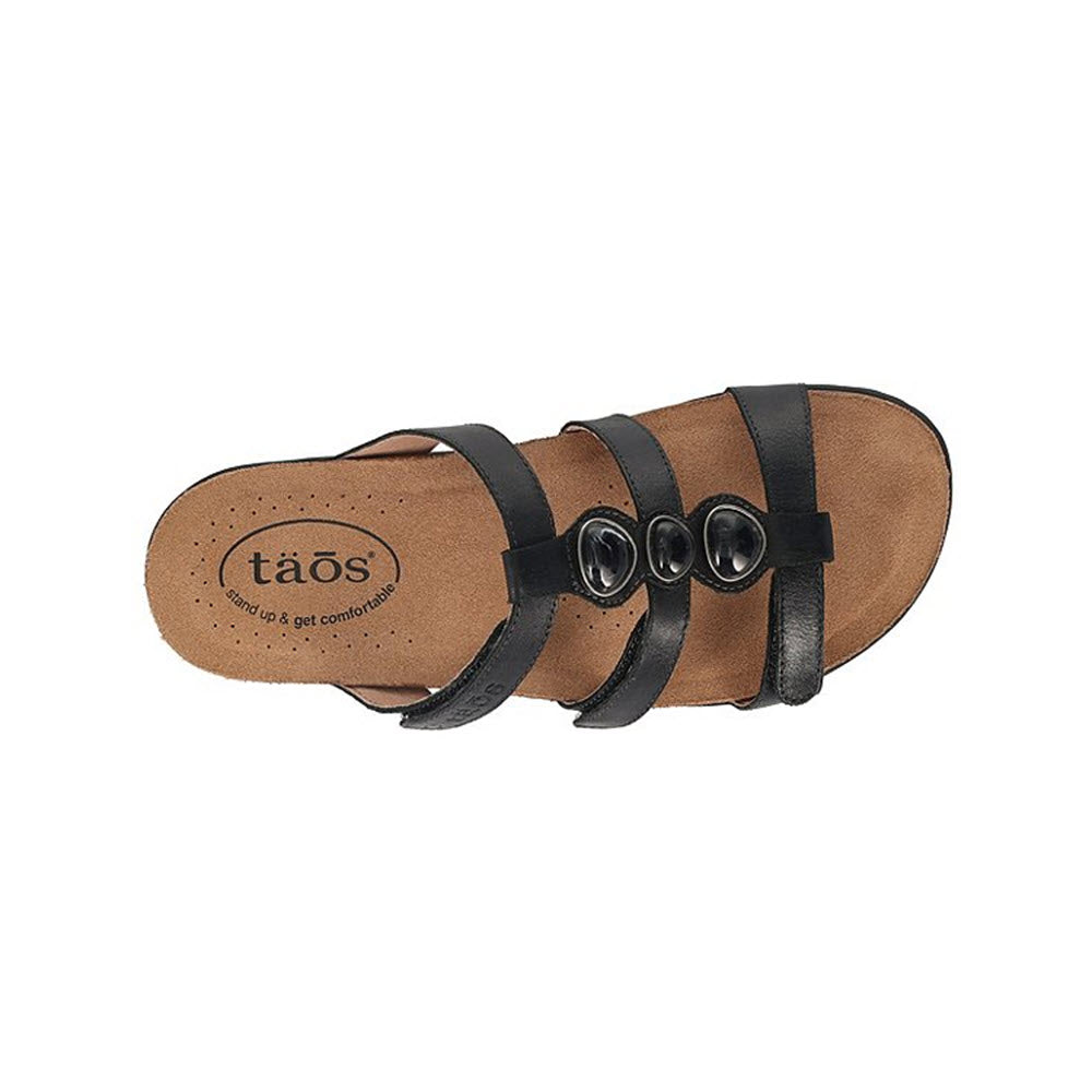 A top view of a Taos Gemma Black sandal with three adjustable black leather straps on a Cork Support™ footbed.