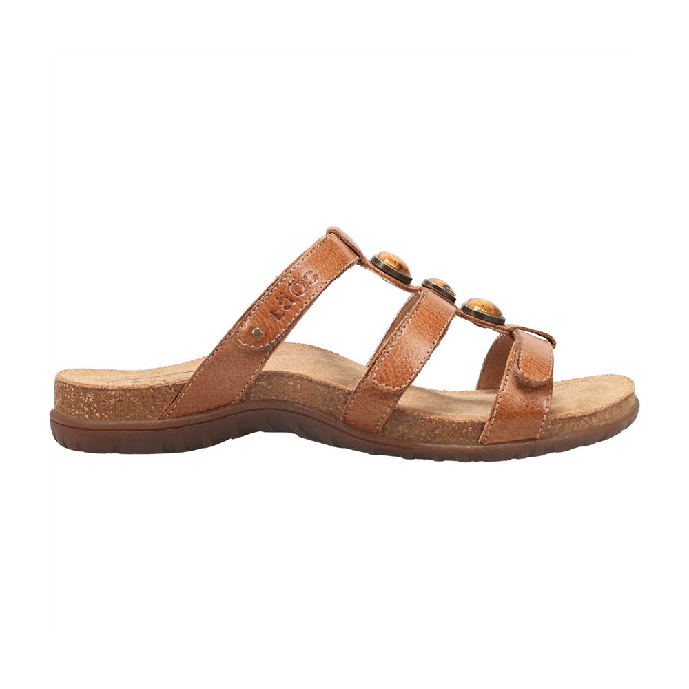 A Taos Gemma Hazelnut sandal with a Cork Support™ footbed and a buckle detail on a white background.