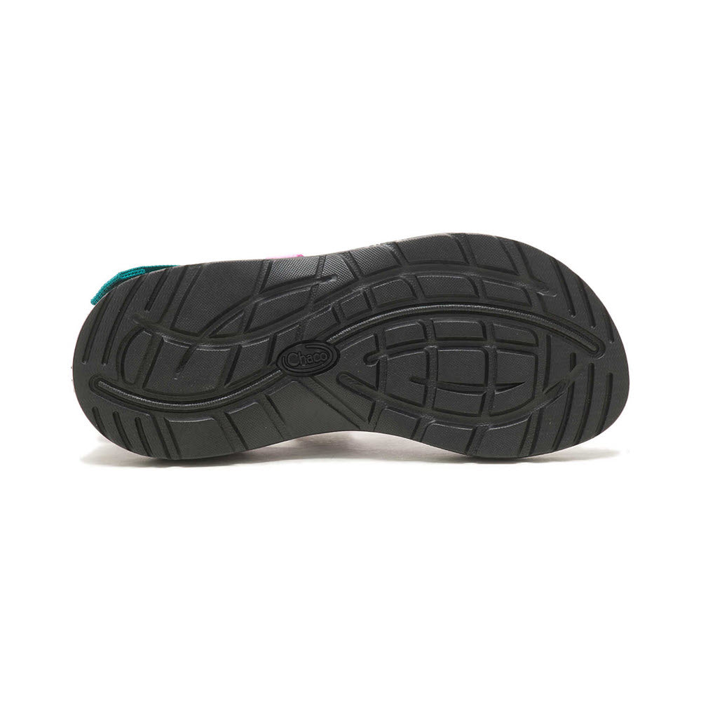Black Chaco sandal sole with ChacoGrip rubber outsole and detailed tread pattern, isolated on a white background.