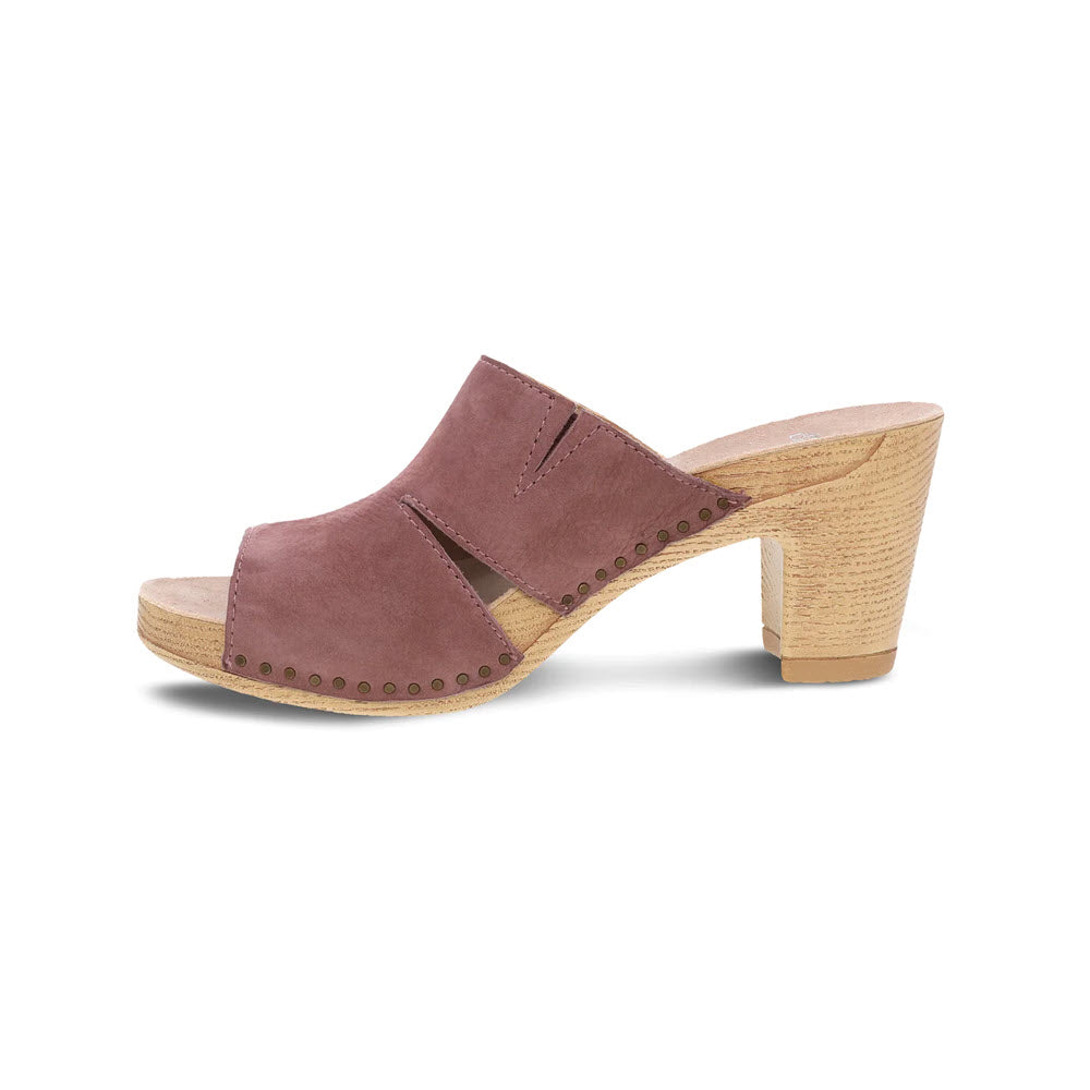 A dusty rose-colored Dansko Tandi sandal with a chunky wooden heel, featuring brass stud details and a peep toe.