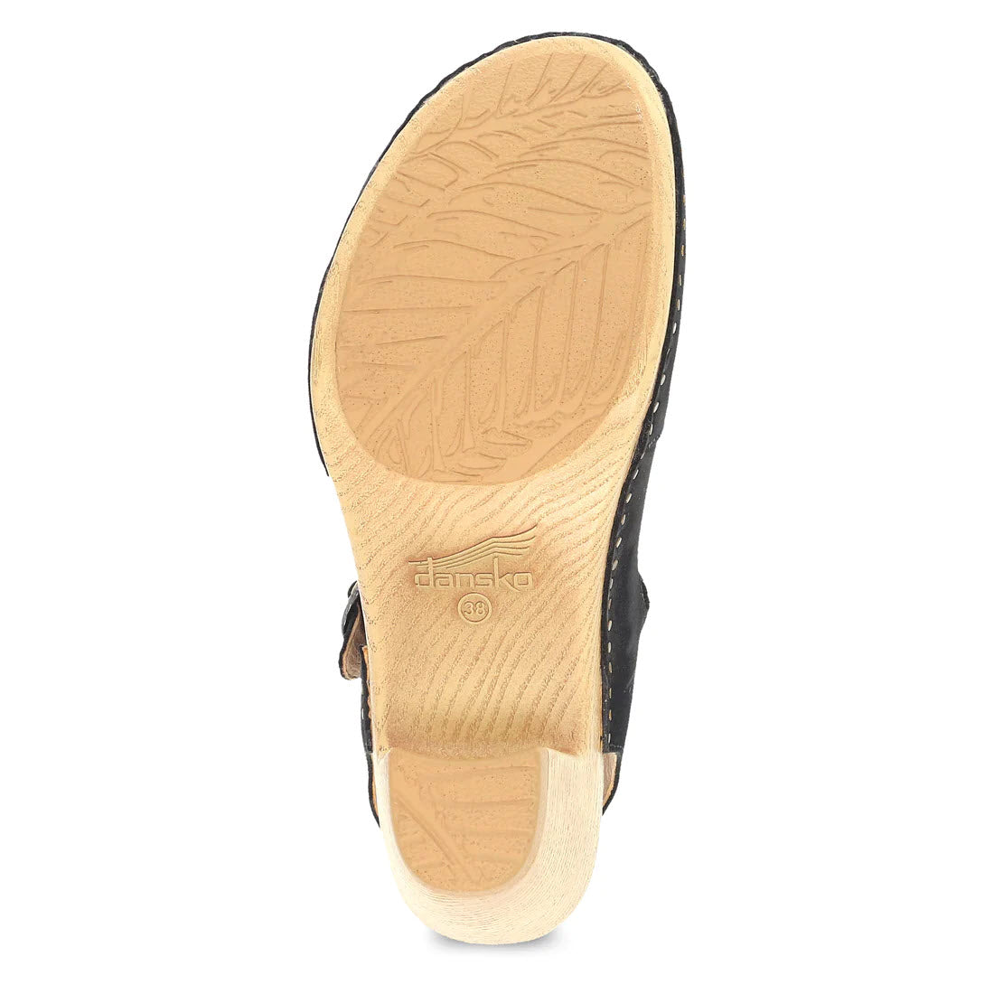Bottom view of a beige heeled sandal with a prominent leaf pattern on the sole and visible Dansko Taytum logo.