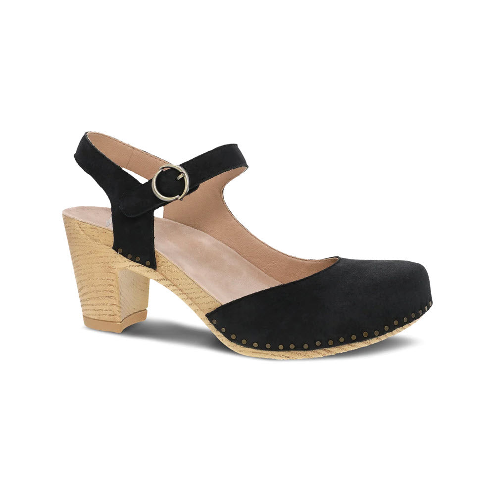 A black suede Dansko Taytum mary jane style shoe with a chunky wooden heel, featuring a strap buckle and gold stud details, isolated on a white background.