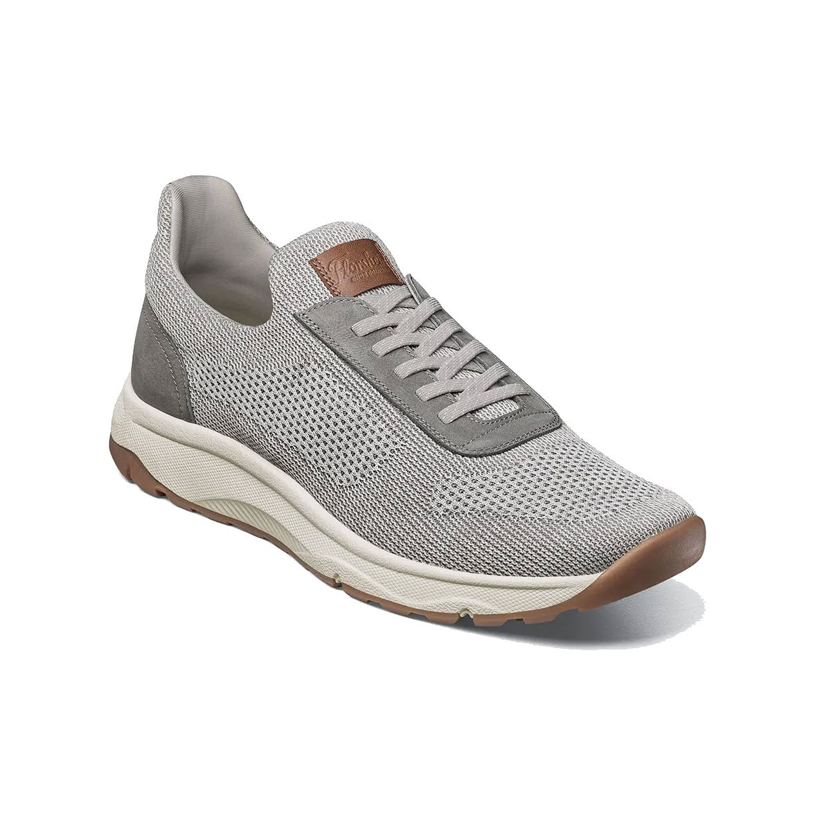 Florsheim dress sneaker with laces, featuring a breathable mesh upper and a contrasting tan leather heel patch on a white sole.