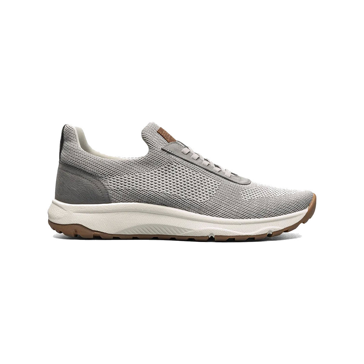 A side view of a Florsheim Satellite Knit Elastic Slip On Sneaker Gray - Mens with a white sole and brown accents on a plain white background.