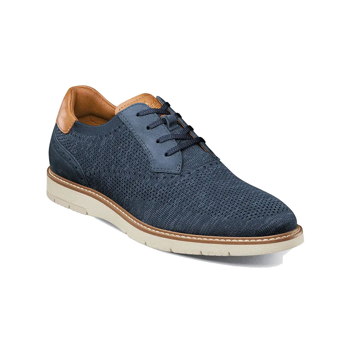 Florsheim navy blue men&#39;s knit oxford dress shoe with a perforated upper, brown leather accents, and a contrasting white sole on a white background.