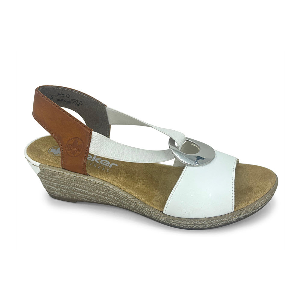 White and brown Rieker women&#39;s everyday wedge sandal with a silver buckle detail on an isolated background.