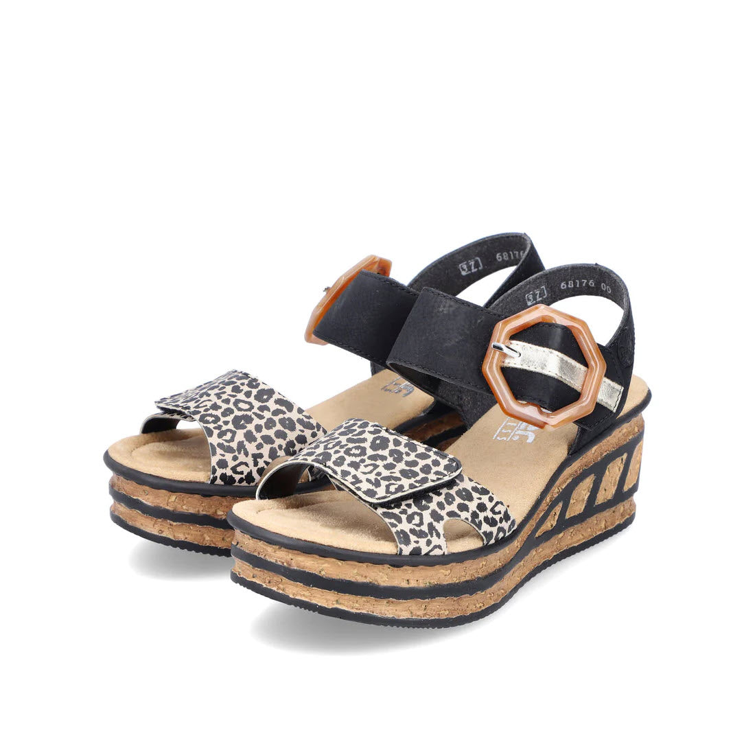 A pair of Rieker RIEKER BIG BUCKLE WEDGE LEOPARD MULTI - WOMENS with animal print straps and cork heels, isolated on a white background.