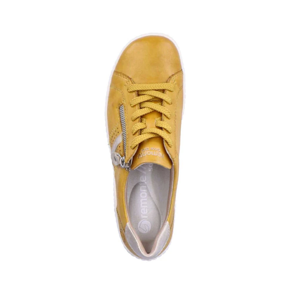 A single Remonte mustard leather upper sneaker with laces and a zipper on a white background.