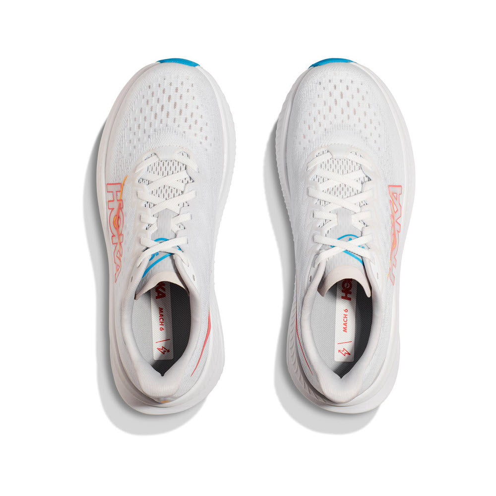 A pair of white HOKA MACH 6 running shoes with orange and blue accents, viewed from above on a white background.