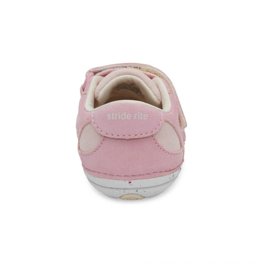 A rear view of a pink Stride Rite SM Sprout toddler&#39;s shoe with a velcro strap, white sole, and memory foam interior.