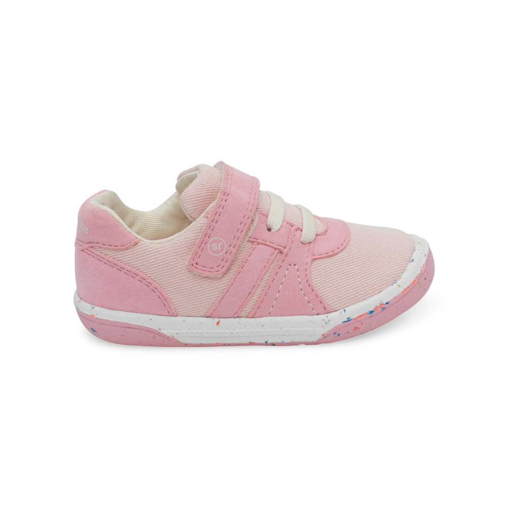 A single pink child&#39;s Stride Rite SR Fern Pink Sneaker with velcro straps and a white sole speckled with blue and pink.