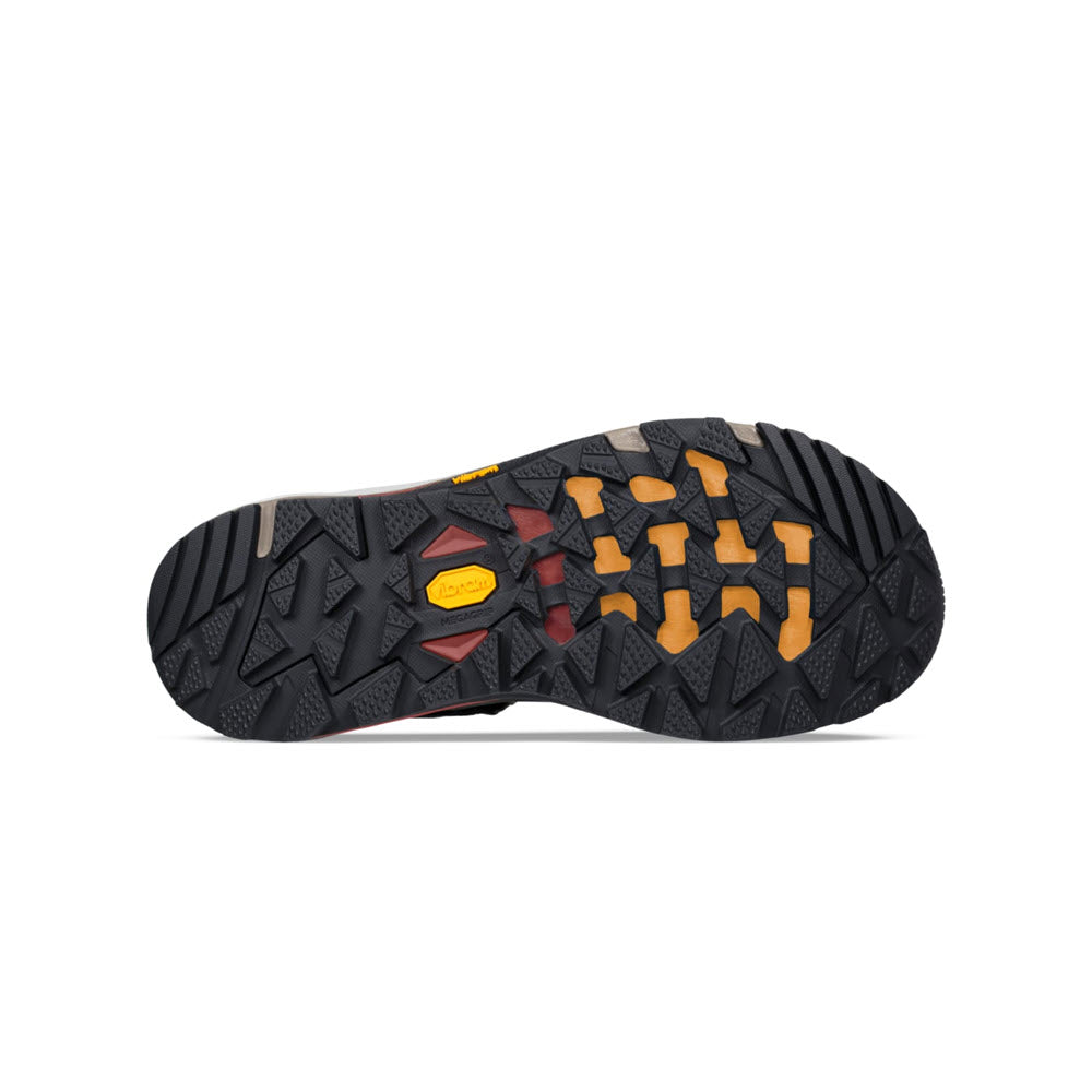 Bottom view of a rugged Teva Grandview GTX Dark Olive hiking boot sole with black tread patterns and a yellow Teva brand logo on it.
