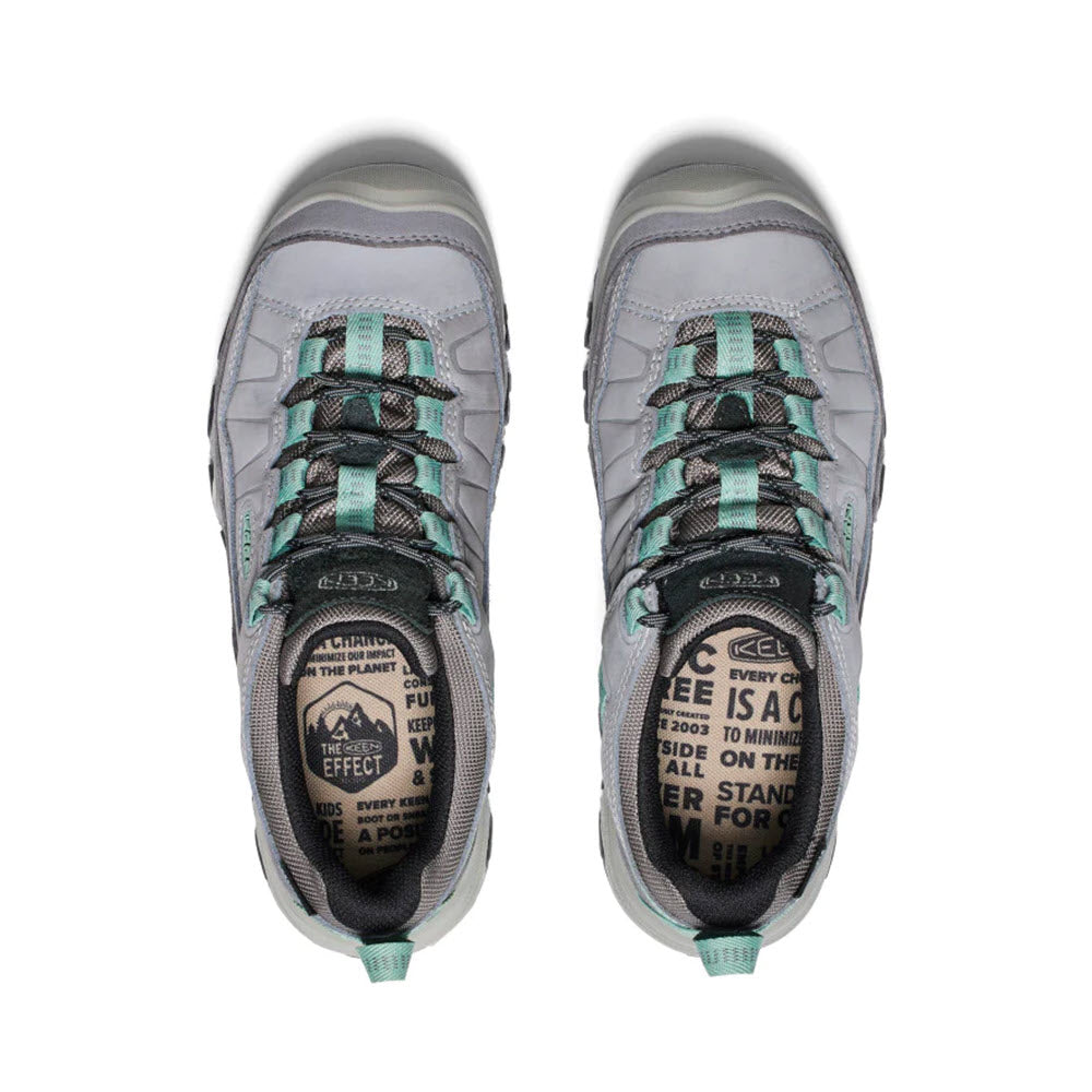 Top view of a pair of Keen Targhee IV WP Alloy hiking shoes with green details, displaying environmental message labels on the tongues, featuring durable Targhee construction.