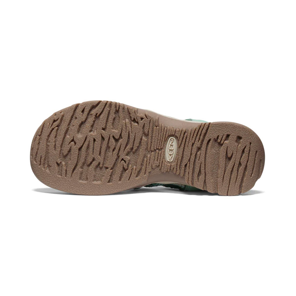 Sole of a Keen Whisper Granite Green - Womens hiking sandal displaying intricate tread pattern and a circular logo at the center.