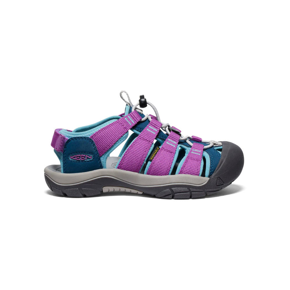 A single Keen Newport Boundless Youth Legion Blue kids&#39; adventure sandal displayed against a white background, featuring purple and turquoise straps with a gray sole.