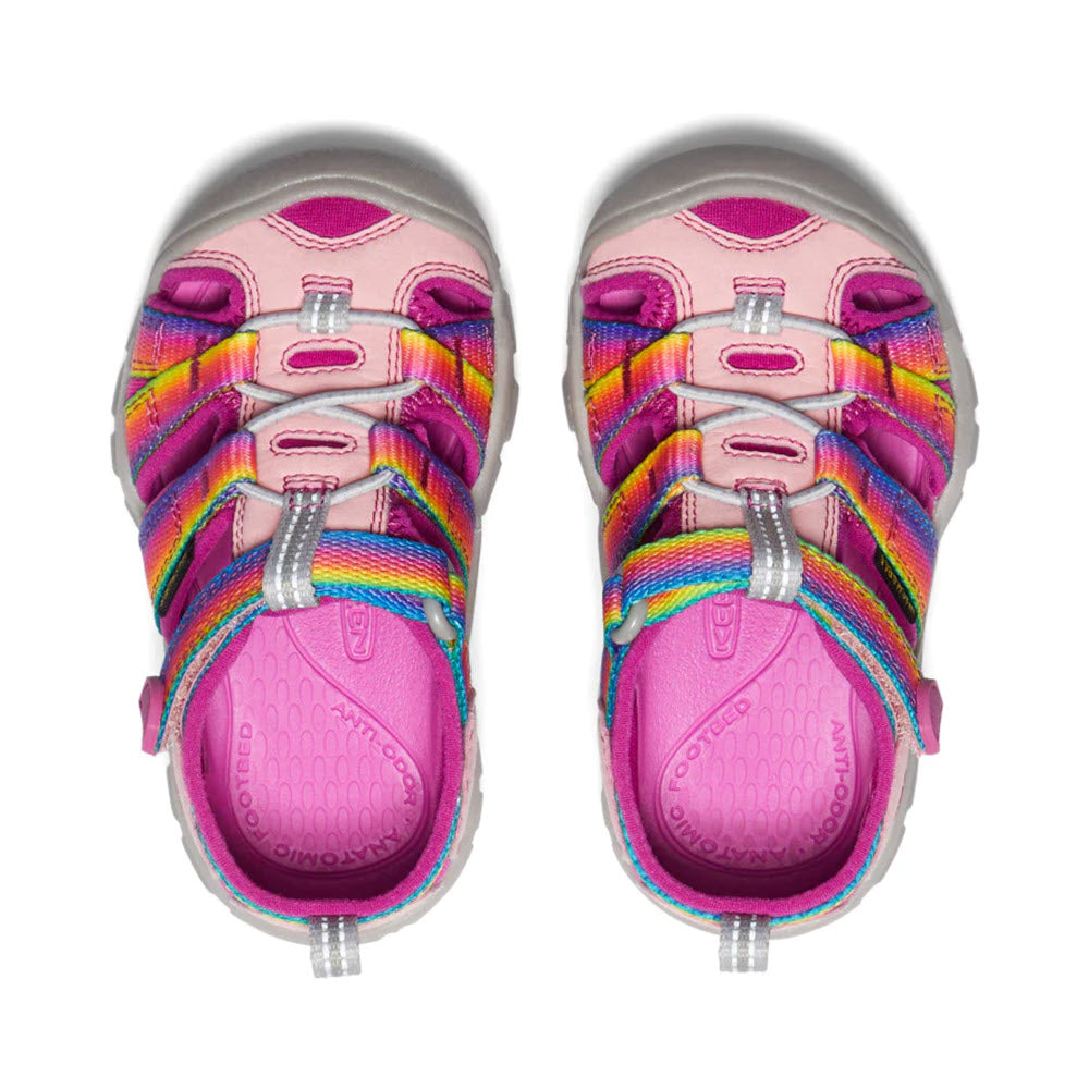 A pair of vibrant pink and multicolored Keen Seacamp II CNX Tots Rainbow water sandals for children with adjustable straps, viewed from above.