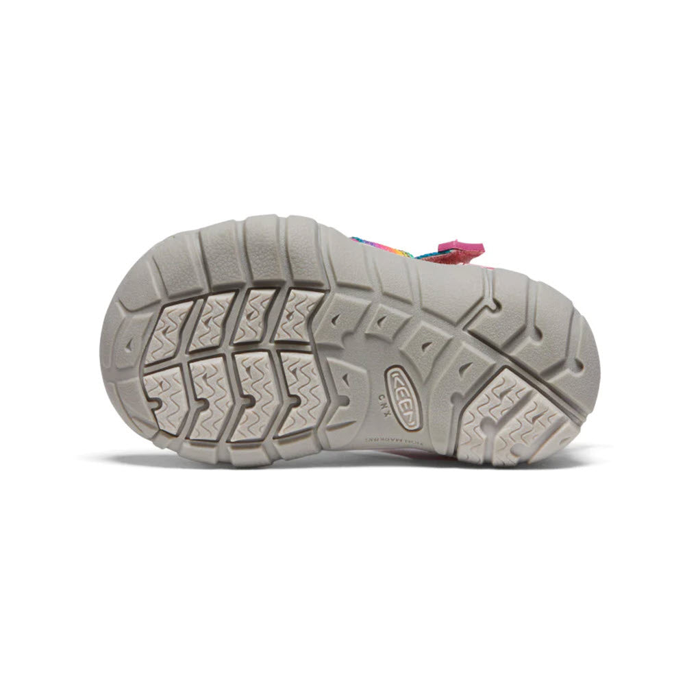Sole of a multicolored KEEN SEACAMP II CNX TOTS RAINBOW - KIDS hybrid water sandal with a detailed tread pattern, displaying the brand name &quot;Keen&quot; embossed in the center.