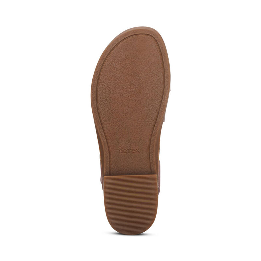 A bottom view of a single Aetrex Tamara Red - Womens shoe sole with textured patterns, memory foam footbed, and the brand name &quot;Aetrex&quot; visible.