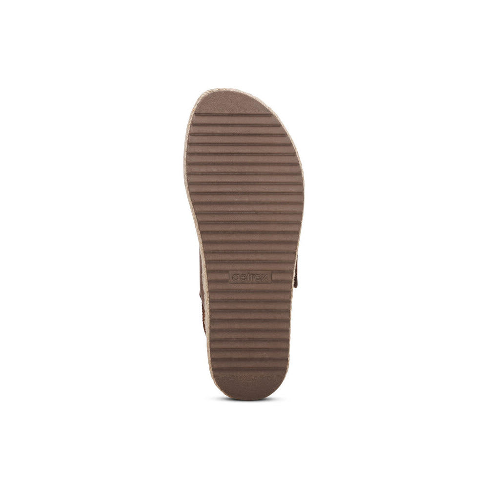 Bottom view of a AETREX VANIA WALNUT - WOMENS shoe displaying a ribbed tan sole with arch support and the Aetrex brand name embossed at the center.