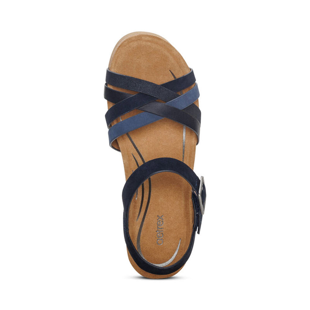 A single Aetrex Noelle Navy - Womens strappy sandal with a suede footbed and adjustable hook &amp; loop closure isolated on a white background.