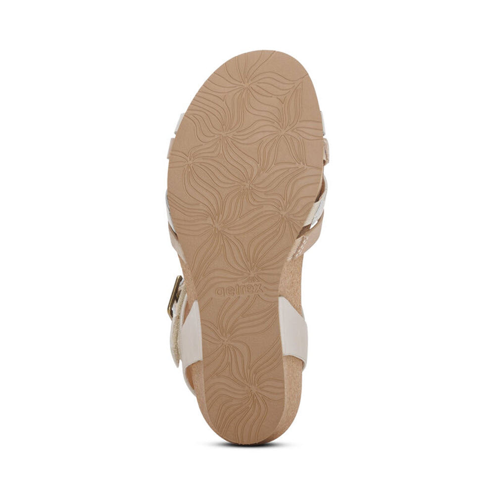 Bottom view of a sandal with beige floral-patterned sole, genuine leather white straps, and adjustable hook &amp; loop closure - Aetrex Noelle Ivory - Womens.