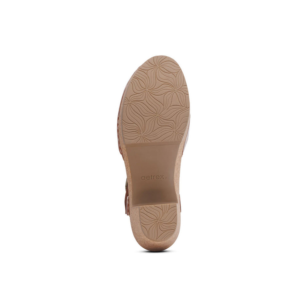 Bottom view of a brown Aetrex Finley Cognac shoe, showcasing a patterned sole with arch support and the brand name visible.