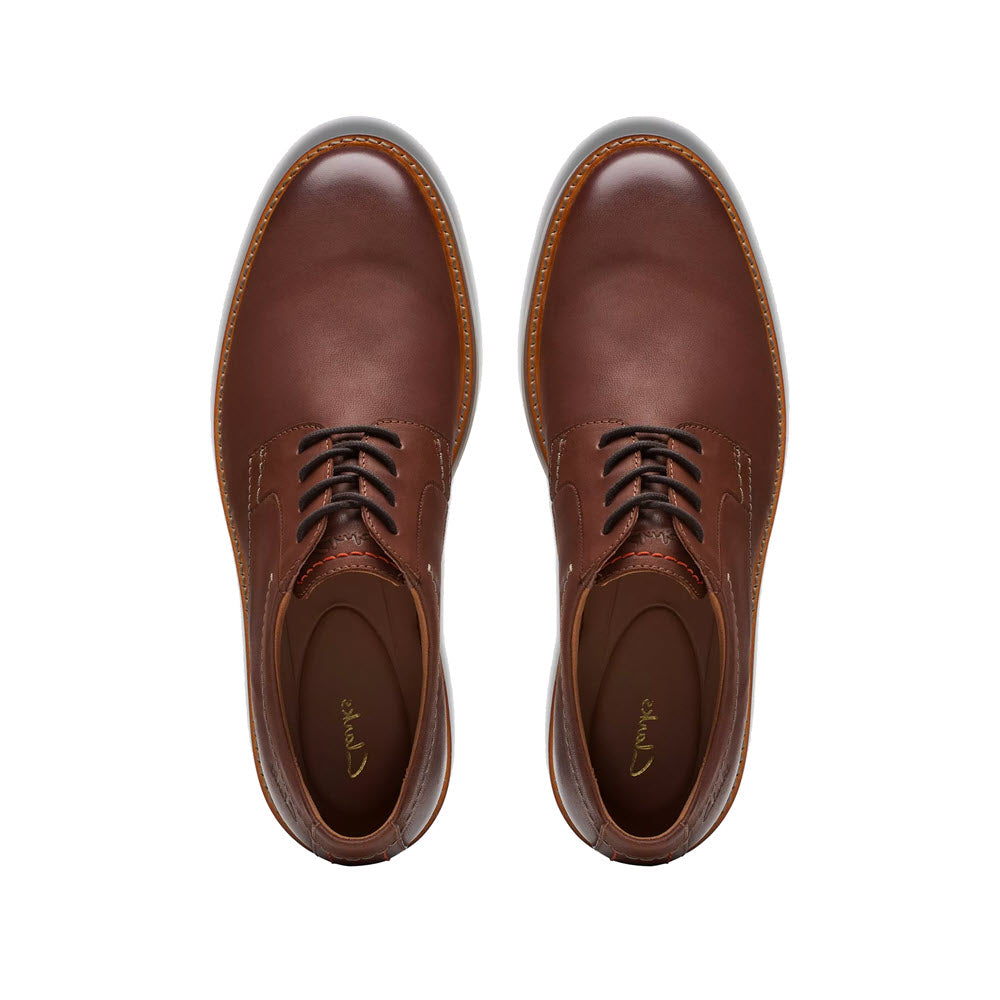 A pair of Clarks Atticus LT Lace Oxford Dark Tan Leather dress shoes viewed from above, featuring neat laces and stitched details.