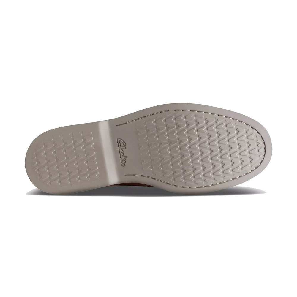 Sole of a stylish Clarks Atticus LT Lace Oxford Dark Tan Leather dress shoe displaying the brand name and textured tread pattern on a white background.
