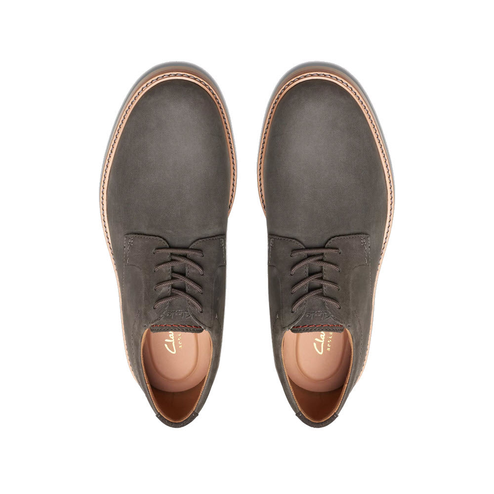 A pair of Clarks Atticus LT Lace Oxford Grey Nubuck shoes with brown soles, viewed from above.