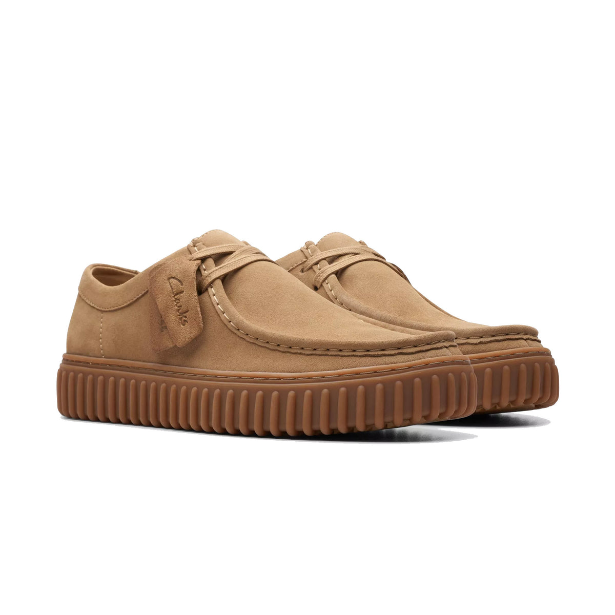 A pair of light brown leather Clarks Torhill Low Oxford shoes with a ribbed outsole, isolated on a white background.