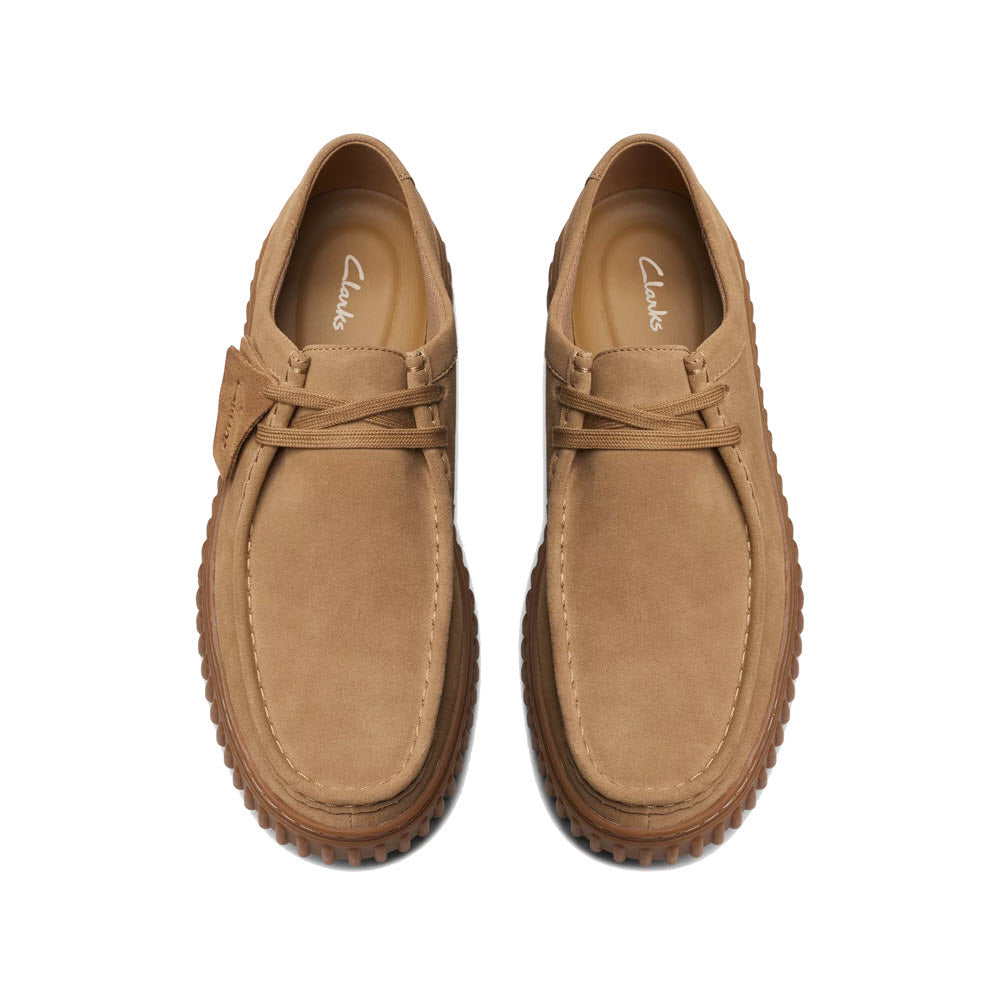 A pair of tan suede Clarks Torhill Low loafers with laces, viewed from above on a white background.