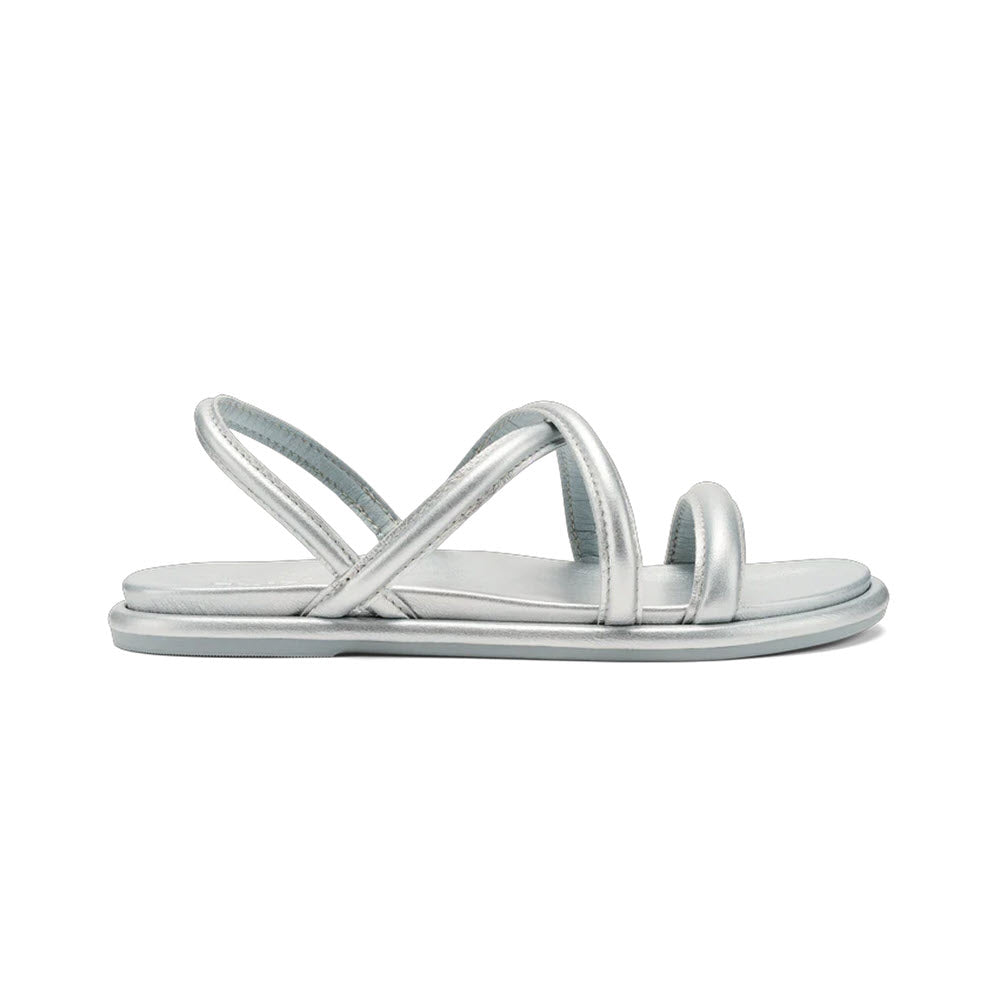 A pair of metallic silver Olukai Tiare Strappy sandals with crisscross straps, isolated on a white background.