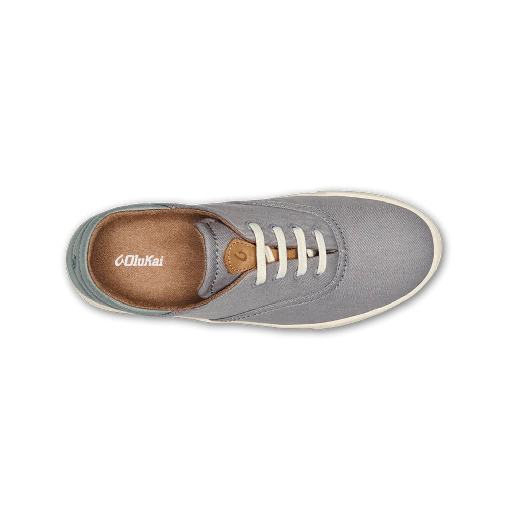 Top view of a gray Olukai Kohu Mist Grey sneaker with white laces and a brown leather accent on the tongue, designed for maximum comfort.