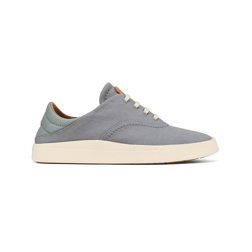A single Olukai Kohu Mist Grey minimalist sneaker with a cream sole and white laces, displayed on a white background.