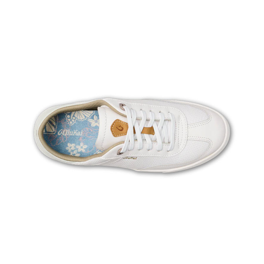 Top view of a Olukai Kilea White sneakers with laced-up white shoelaces and a floral pattern inside the shoe.