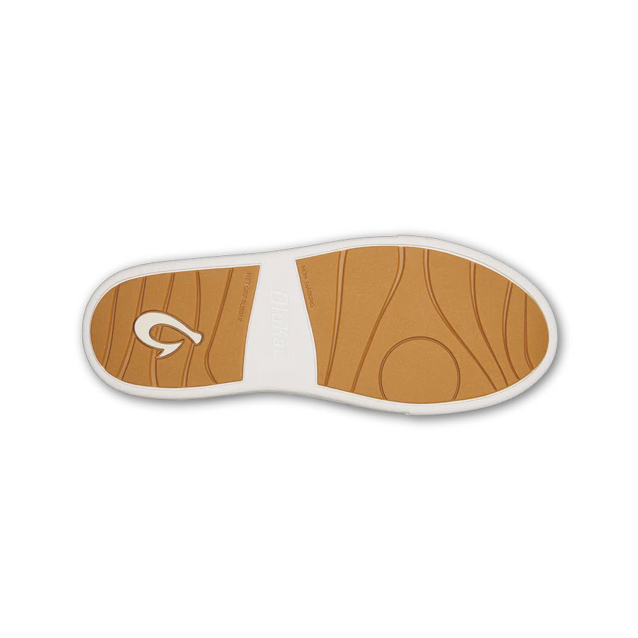 Sole of an Olukai Kilea White shoe, featuring a tan and white design, circular logo, and textured patterns for cloud-like comfort.