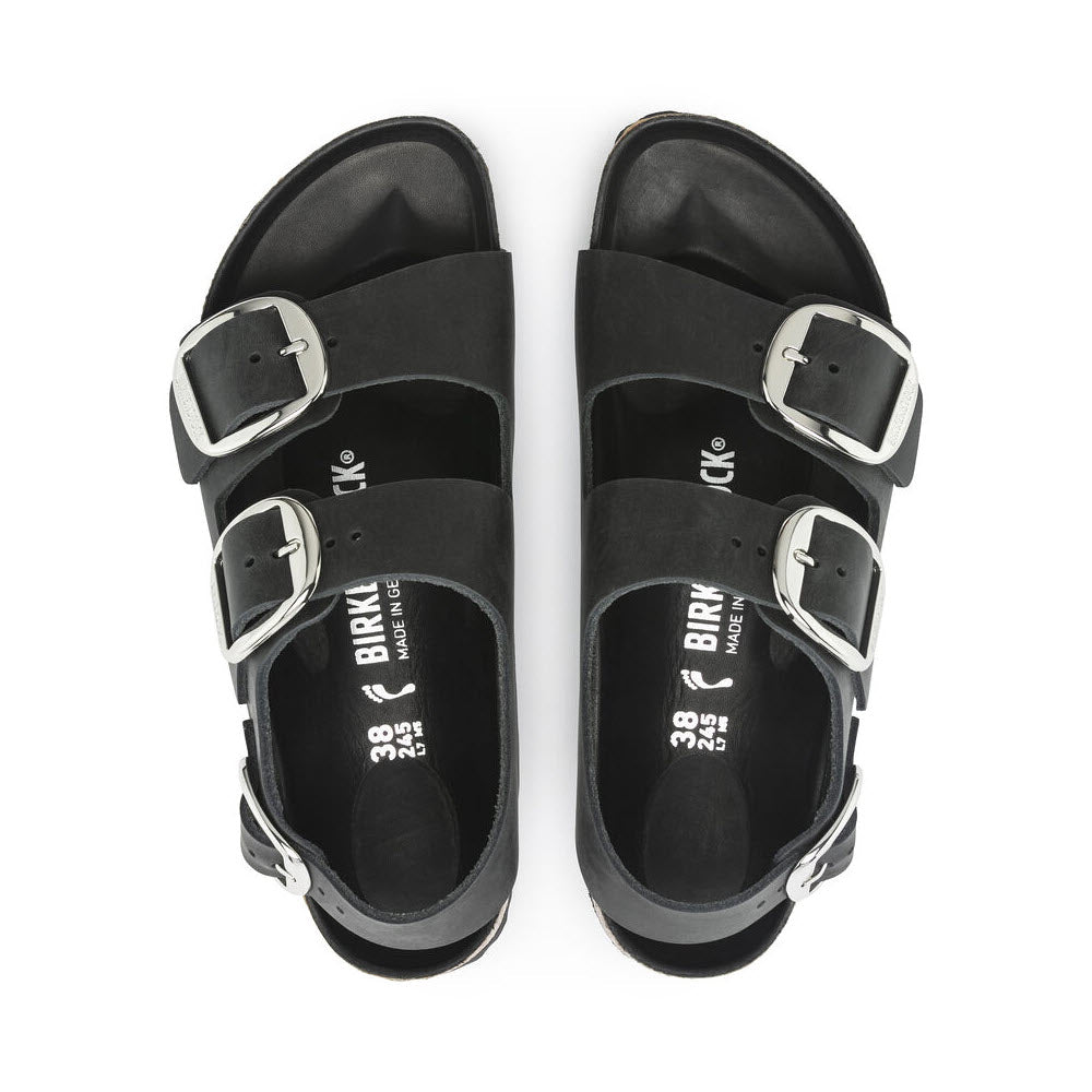 A pair of black Birkenstock Milano Big Buckle Black sandals with three adjustable straps, crafted from oiled nubuck leather, viewed from above on a white background.