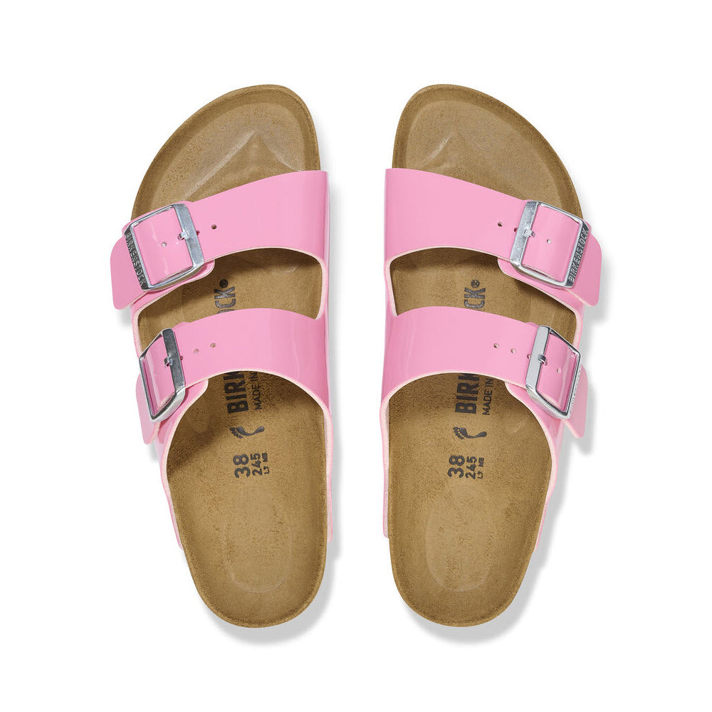 A pair of pink Birkenstock Arizona Patent Candy Pink sandals with adjustable straps, viewed from above on a white background.