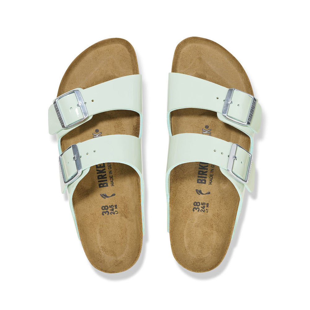 A pair of Birkenstock Arizona Patent Surf Green women&#39;s sandals with a timeless design and buckles on a white background.