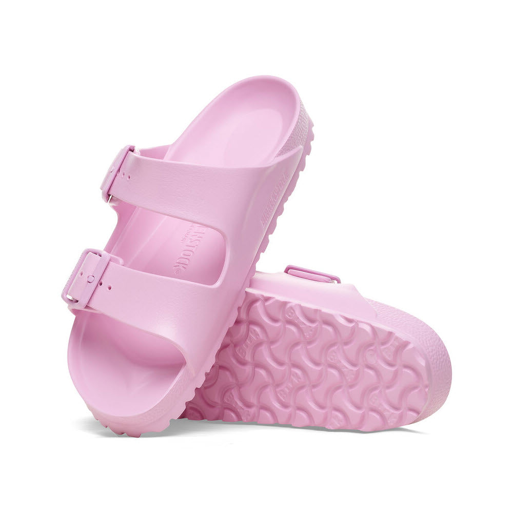 A pair of Birkenstock Arizona Eva Fondant Pink sandals with buckles and a textured sole, isolated on a white background.