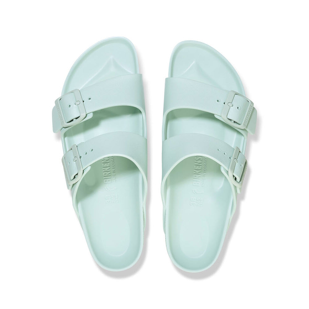 A pair of mint green BIRKENSTOCK ARIZONA EVA SURF GREEN - WOMENS sandals with adjustable straps, viewed from above on a white background. (Brand Name: Birkenstock)