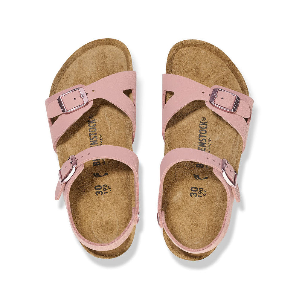 A pair of pink Birkenstock Rio Pink Clay Birkibuc sandals with an adjustable ankle strap and contoured footbed, displayed against a white background.