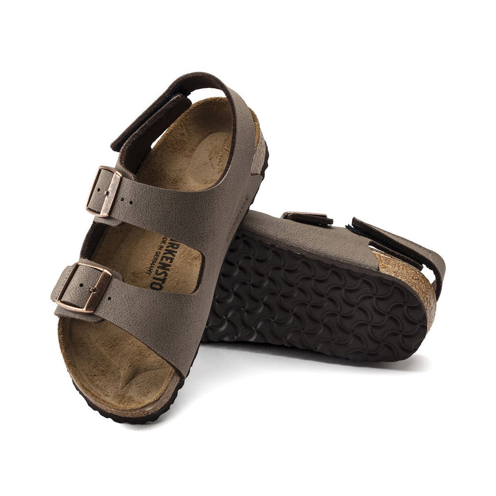 A pair of dark brown Birkenstock Milano sandals with adjustable straps and contoured cork footbeds, featuring a supportive backstrap, isolated on a white background.