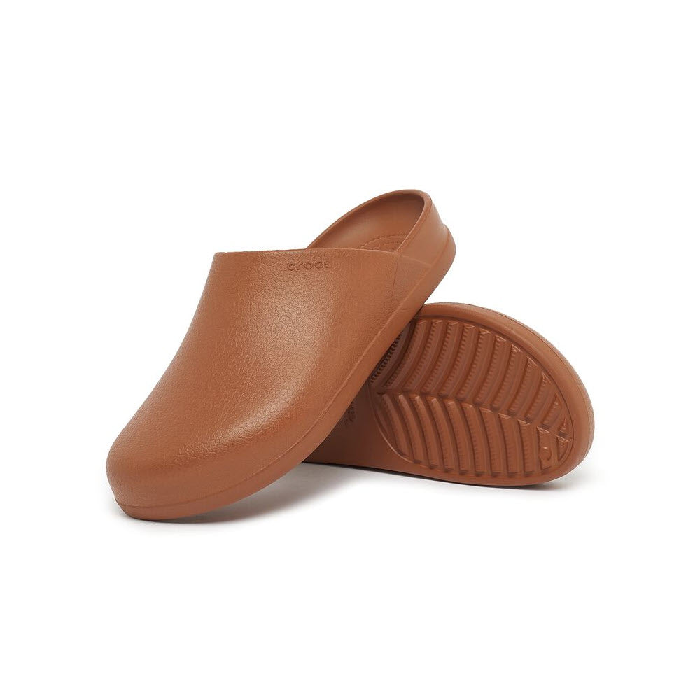 A pair of brown Crocs Dylan Clog Cognac - Womens isolated on a white background, angled view showing the top and sole.