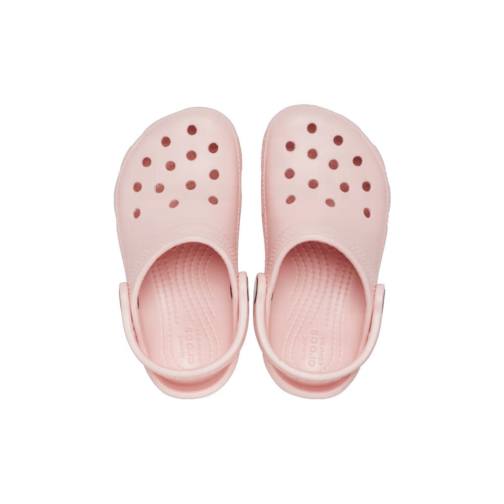 A pair of kids&#39; pink rubber Crocs Classic Clog Quartz, with circular holes on the top, viewed from above on a white background.