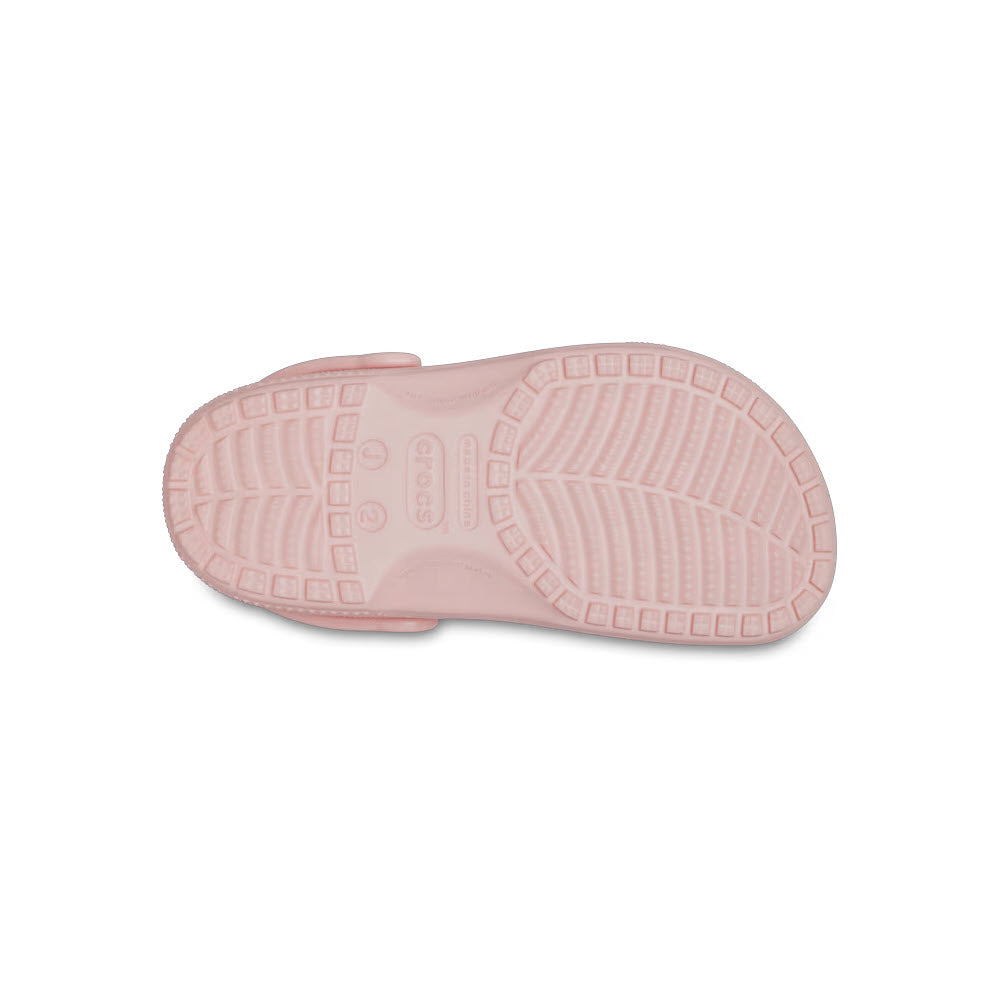 Bottom view of a pink kids&#39; Crocs Classic Clog Quartz sole showing tread pattern and brand details.