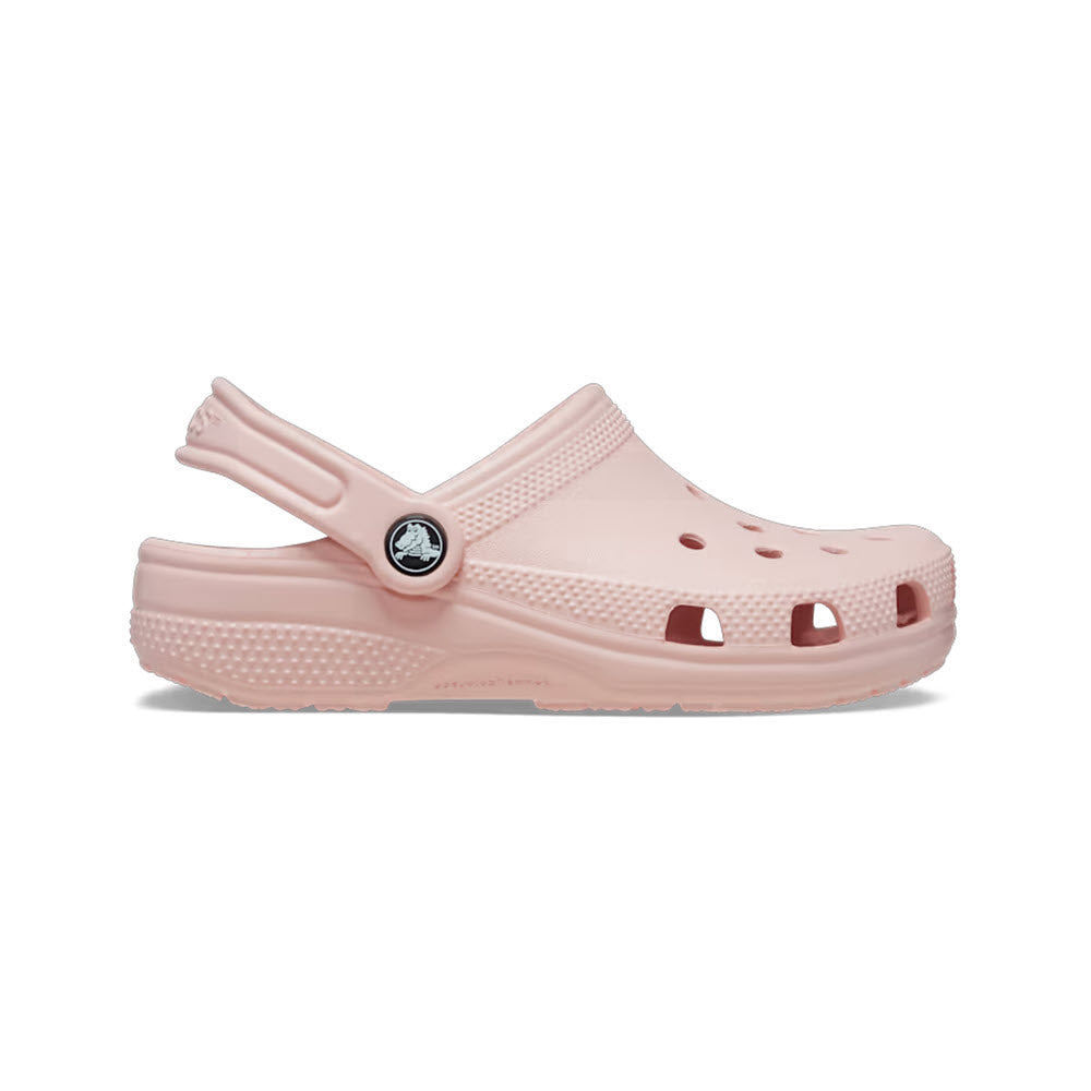 A pale pink kids&#39; Crocs Classic Clog Quartz shoe isolated on a white background, featuring ventilation holes and a pivoting heel strap.