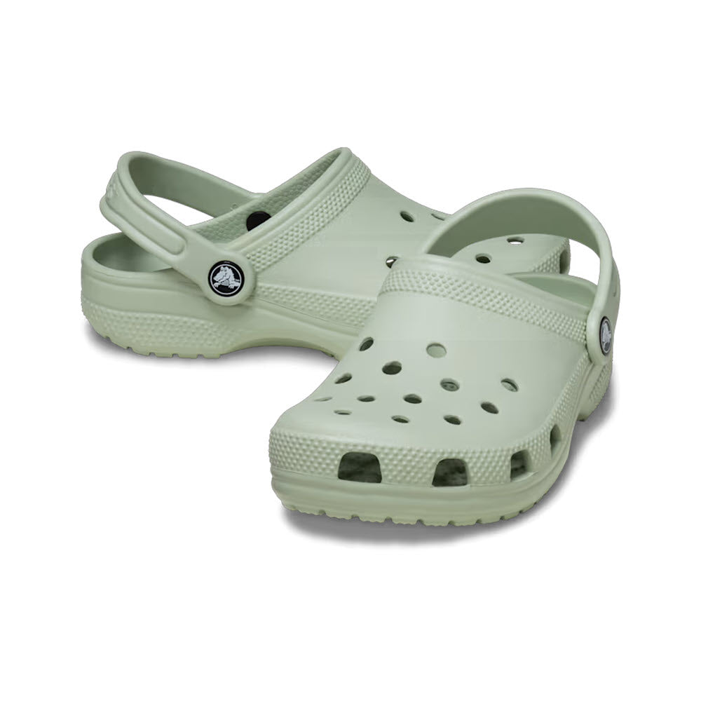 A pair of light green Crocs Classic Clog Plaster for kids on a white background.